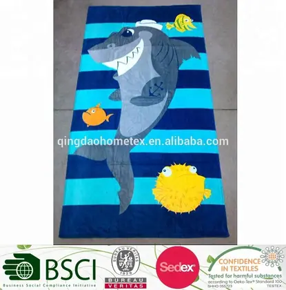 Striped beach towel with cartoon shark and fish appliques, laid on a tiled floor