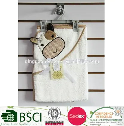 White hooded baby towel with cartoon animal hood hanging on a slatwall hook, with certification logos below