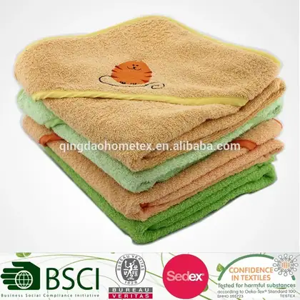 Stack of folded hooded baby towels in tan, green, and orange with a cat applique, with certification logos at bottom