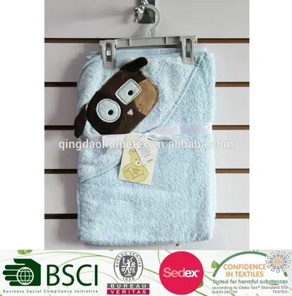 Light blue hooded baby towel with brown puppy face applique on a hanger, with certification logos along the bottom