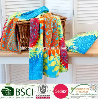 Colorful printed beach towels draped over a wicker basket and folded on a white bench against white shutters