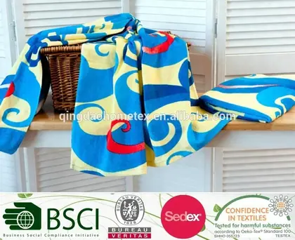 Blue and yellow printed towel fabric draped over a wicker basket on a wooden surface