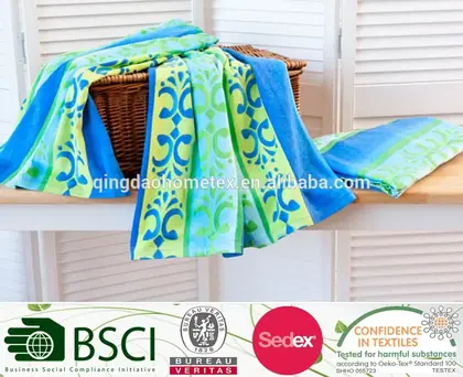 Colorful blue and green patterned towels draped over a wicker basket on a wooden shelf