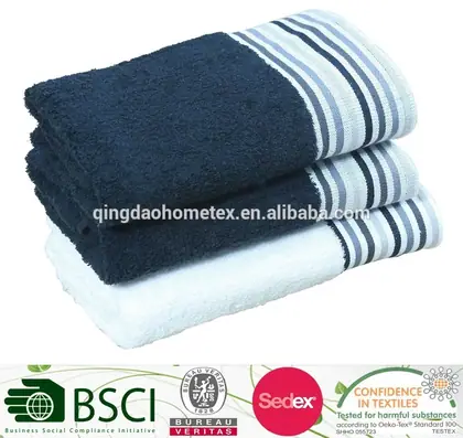 Stack of three folded towels, navy and white with striped borders, on a white background