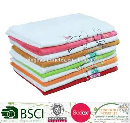 Stack of folded towels in assorted colors with white tops, on a white background with certification logos below