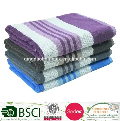 Stack of folded striped towels in purple, grey, and blue on a white background