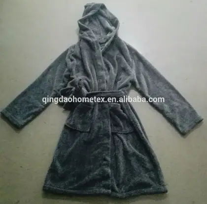 Gray hooded fleece bathrobe with tie belt laid flat on a concrete floor
