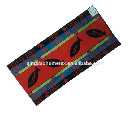 Rectangular woven rug with red center panel, black fish motifs, and geometric blue, green, and red borders on a white background
