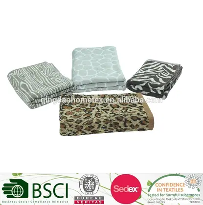 Four folded blankets with animal-print jacquard patterns (zebra, leopard, giraffe) on a white background