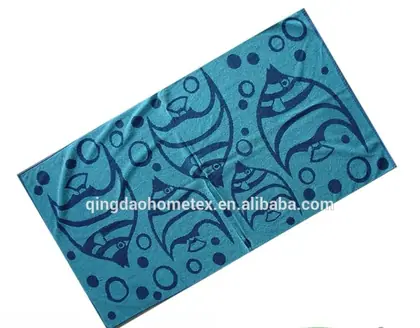 Teal beach towel with dark blue fish and bubble print, shown diagonally with BSCI and Confidence in Textiles certification logos below