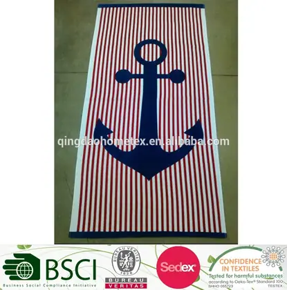 Red and white striped towel with a large navy anchor design, photographed flat on a floor