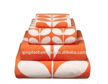 Stack of folded orange towels with white leaf pattern on white background, with BSCI and Confidence in Textiles logos below