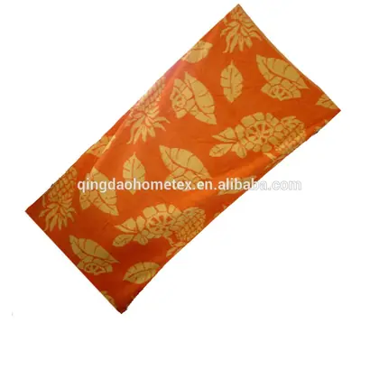 Orange beach towel with yellow leaf and floral print, diagonal on white background