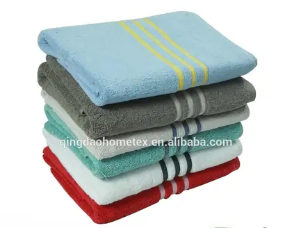 Stack of folded towels in blue, grey, teal, white, and red with striped borders, plus BSCI and Oeko-Tex certification logos below