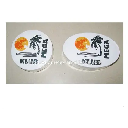 Two oval white printed stickers with palm tree, sun, and KLIK MEGA text on a beige surface