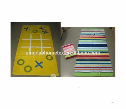 Two flat-woven towels: a yellow tic-tac-toe game towel and a multicolor striped towel on a concrete floor