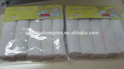 Two retail packs of white handkerchiefs in plastic bags with yellow printed headers on a table