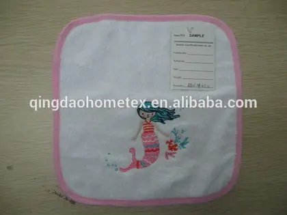 White baby towel with pink border and embroidered mermaid design, with sample tag attached
