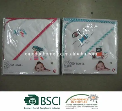 Two packaged embroidered hooded baby towels with mitts on a dark floor, with BSCI and Confidence in Textiles certification logos below