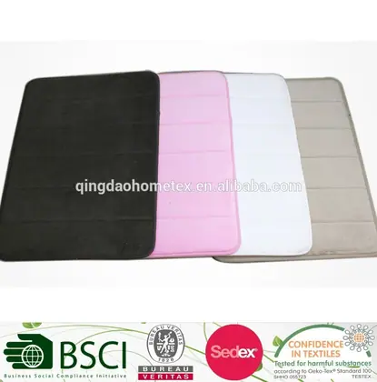 Four memory foam bath mats in black, pink, white, and beige fanned out on a white background