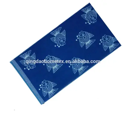 Blue folded towel with white fish prints shown diagonally on a white background