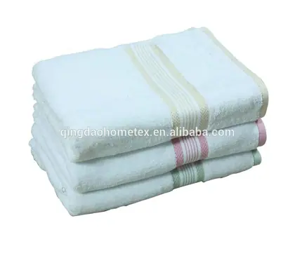 Stack of three folded white terry towels with pastel stripes on white background