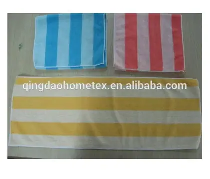 Three striped towels in blue, pink, and yellow laid flat on a wooden surface