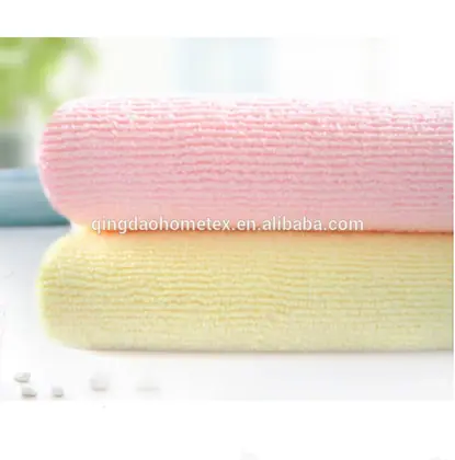 Two rolled microfiber towels, one pink and one yellow, stacked on a white surface