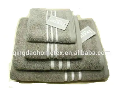 Stack of folded grey towels with white stripes and paper tags