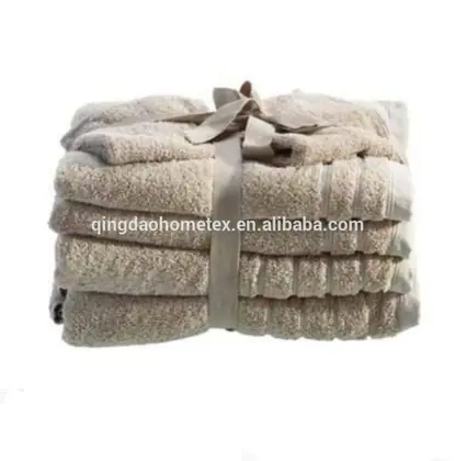 Stack of folded beige towels tied with a ribbon against a white background