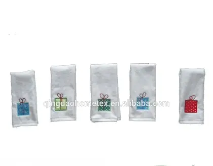 Five white towels with embroidered gift-box designs in different colors, hanging in a row on white background