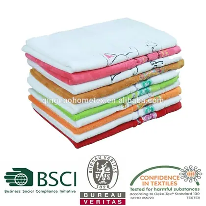 Stack of folded colorful embroidered towels on white background with certification logos and watermark text below