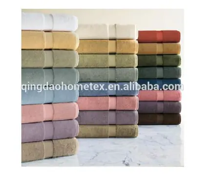 Stacks of folded towels in various colors arranged on a marble surface.