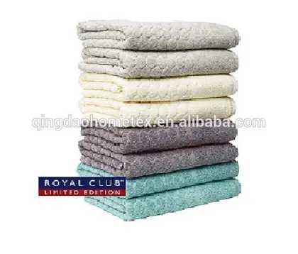 Stack of folded towels in gray, cream, purple, and teal colors on a white background