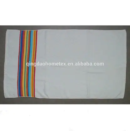White towel with multicolored vertical stripes near one end, laid flat on a grey surface