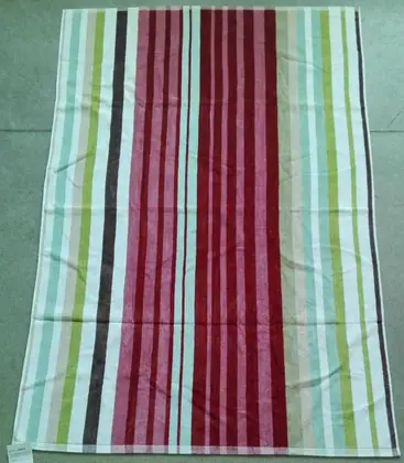 Multicolored striped towel in burgundy, pink, green, and white lying flat on a grey floor