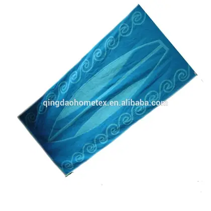 Blue beach towel with white surfboard-style motif and spiral border patterns, shown tilted on white background