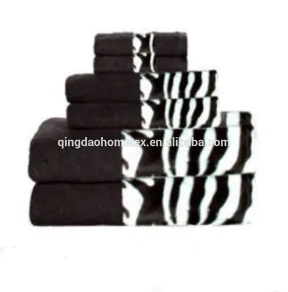 Stack of folded black towels with black-and-white zebra-print borders, arranged in a pyramid