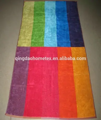 Multicolored striped beach towel with wide vertical color blocks laid flat on a tiled floor