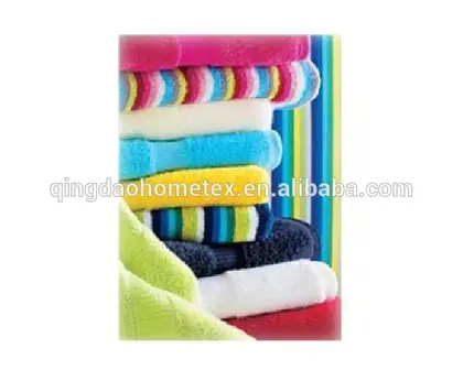 Stack of colorful folded towels in pink, blue, yellow, green, and striped patterns against a striped background