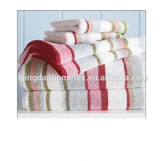Stack of folded striped towels in red, pink, green and white on a white shelf