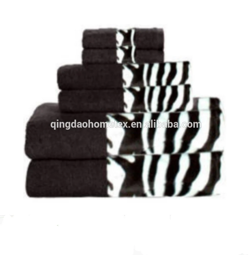 Stack of folded black towels with black-and-white zebra-print borders, arranged in a pyramid