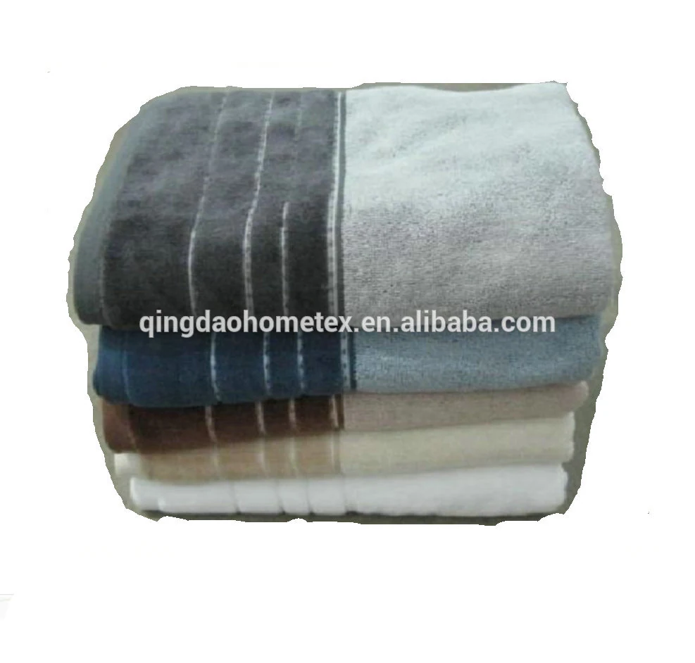 Stack of folded terry towels in gray, blue, beige and white with striped bands