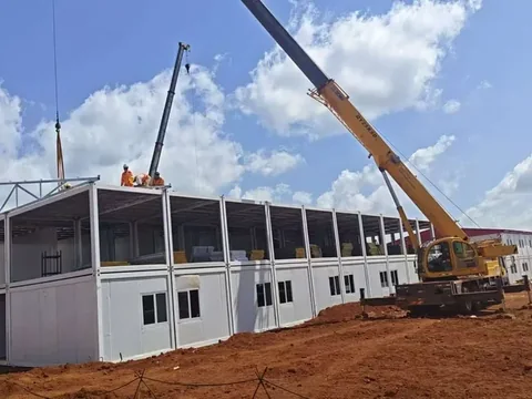 Camp modules being lifted into position by crane on the Simandou site