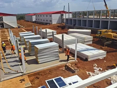 Flat-packed wall and floor panels for detachable container houses stacked on a camp site