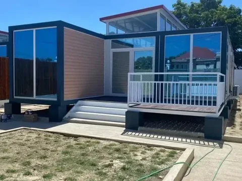 Expandable container house with glazed front elevation and external deck