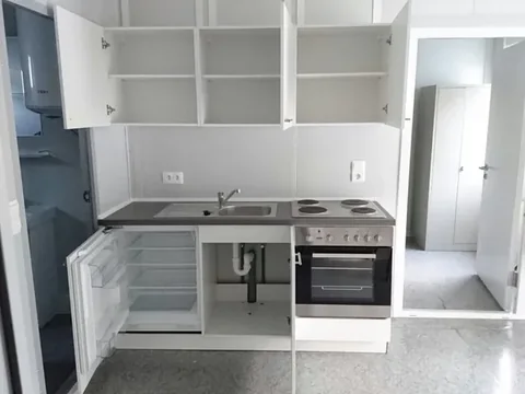 Fitted kitchen with cabinets appliances and worktop inside a container module