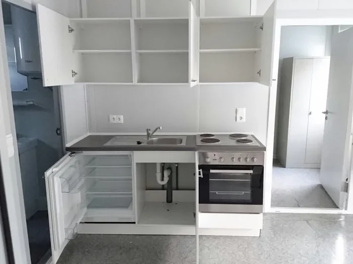 Fitted kitchen with cabinets appliances and worktop inside a container module