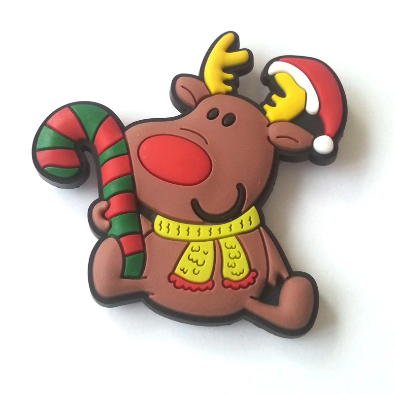 Soft PVC magnet of a smiling brown reindeer in a red Santa hat and yellow scarf beside a striped candy cane