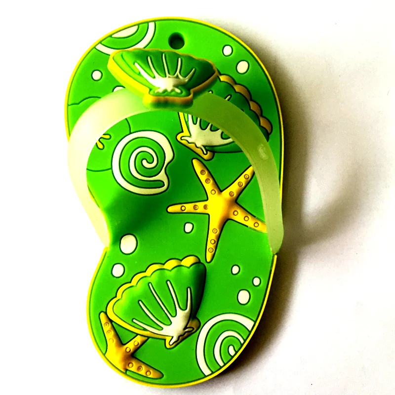 Green soft PVC magnet shaped as a flip flop decorated with a starfish shells and swirl patterns